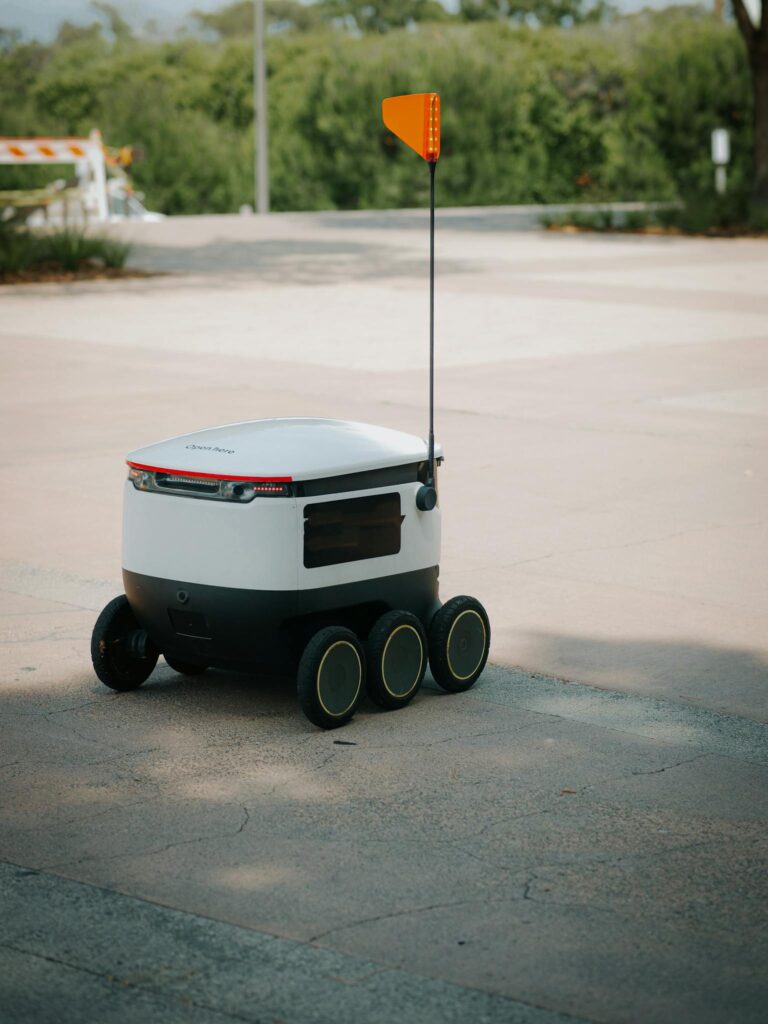 Futuristic delivery robot for food transportation on a sunny day.