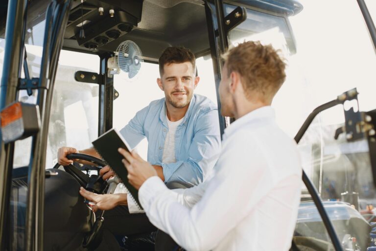 Two men collaboratively discussing inside machinery cabin, fostering teamwork.